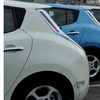 The rear of a row of electric vehicles is shown, in alternating blue and white colors.