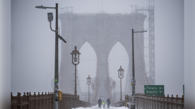 2022年1月29日，行人在暴风雪中穿过布鲁克林大桥